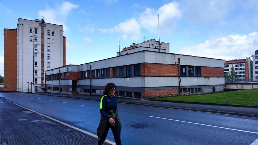 Una mujer, pasando ante el viejo centro de educación de adultos que va a ser derribado, en una imagen tomada ayer. | P. T.