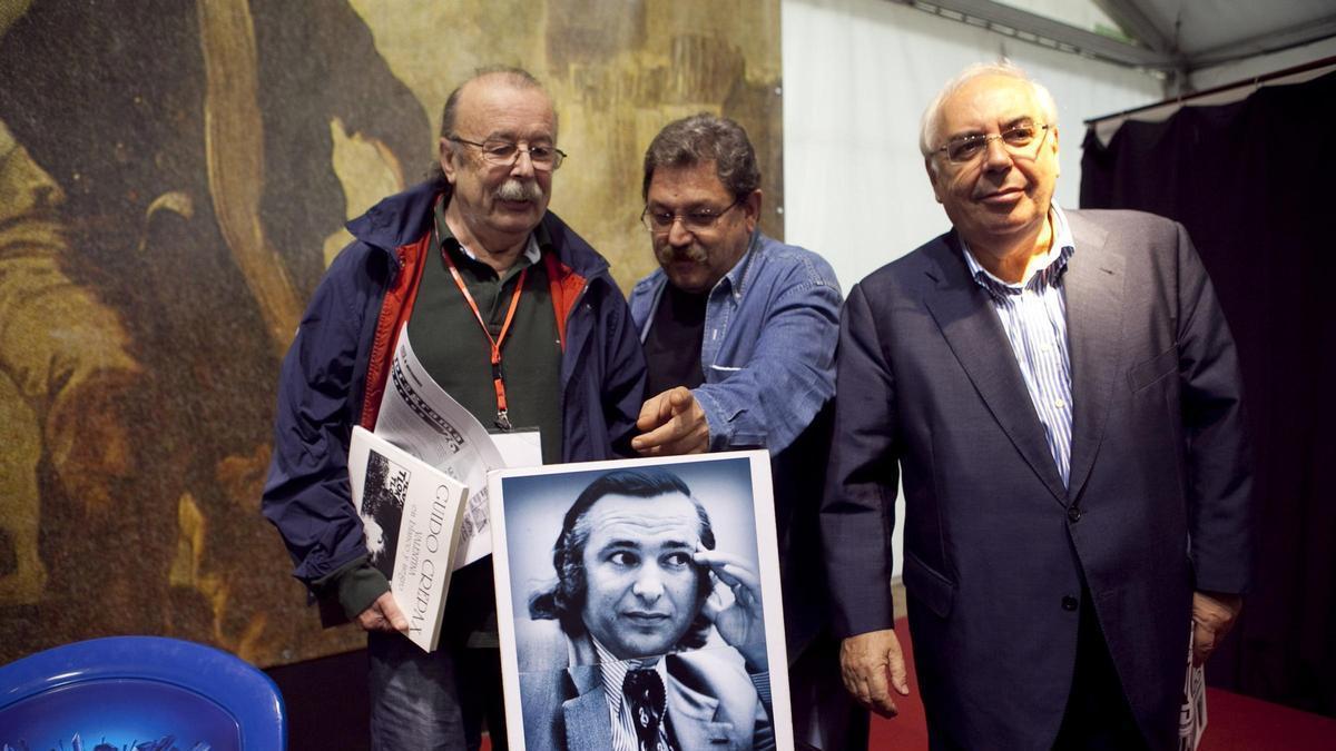 Por la izquierda, Juan Cueto, Paco Ignacio Taibo y Vicente Álvarez Areces; con una fotografía de Silverio R. Cañada en la mesa, en un acto de homenaje a los fundadores de la Semana Negra en 2011.