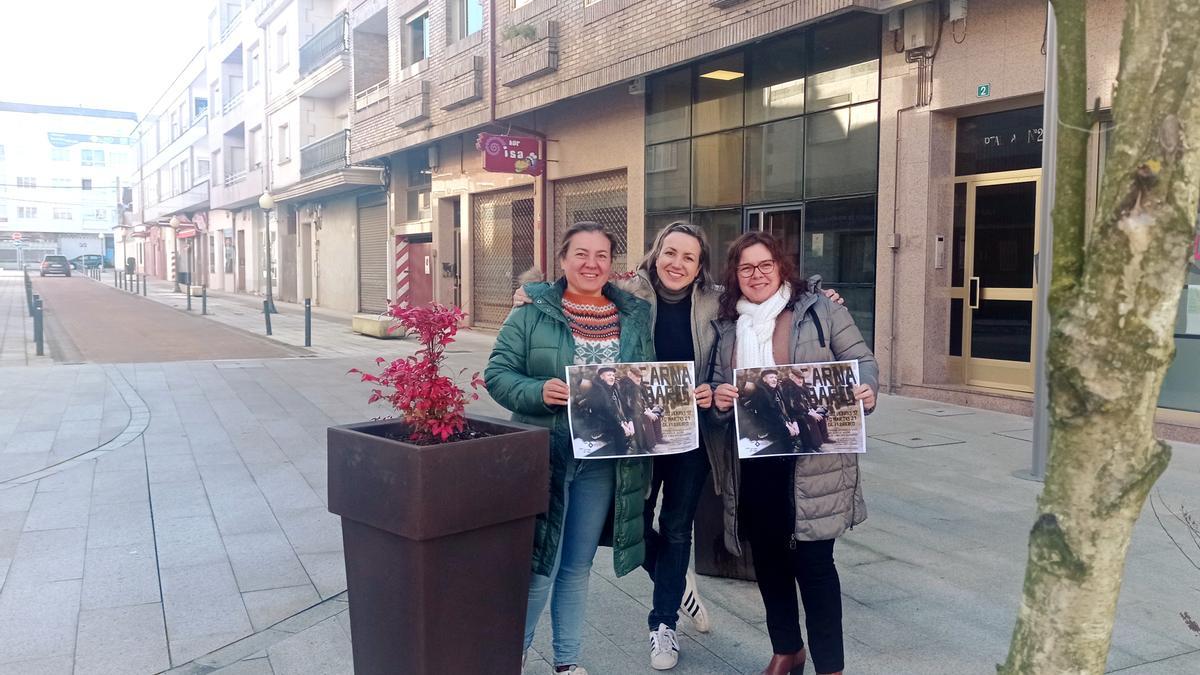 Silvia López , presidenta de ECOS, Estefanía Fernández, secretaria, e Isabel Núñez, tesorera de ECOS, posan con el cartel de la campaña en la Praza Siñor Afranio.