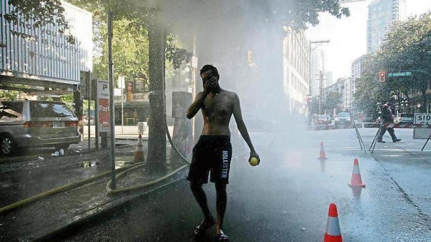 UN hombre trata de refrescarse en Vancouver.