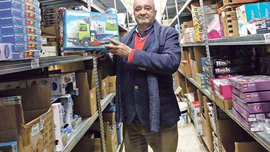 Tomás Cueto posa con cajas de juguetes en su almacén.