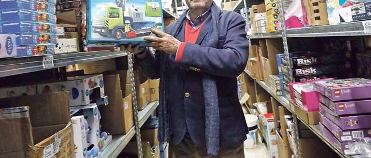 Tomás Cueto posa con cajas de juguetes en su almacén.