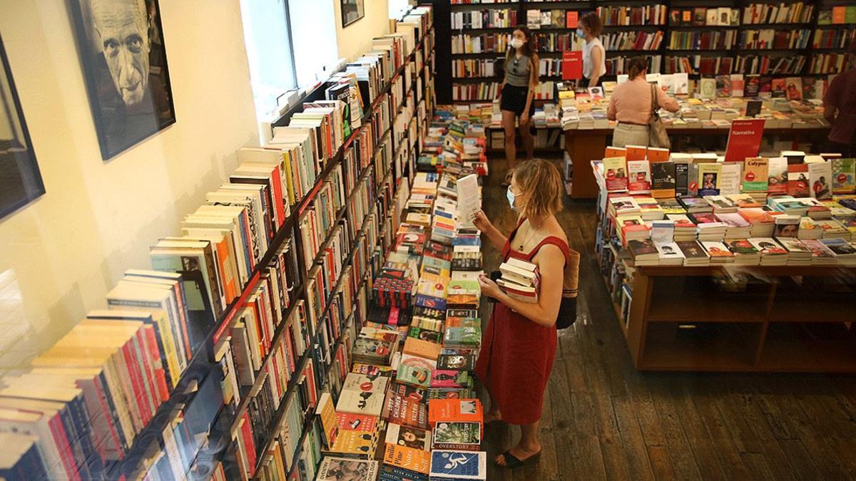 Una mujer lee la contraportada de un libro, en La Central, el pasado 23 de julio, día del llamado Sant Jordi de verano