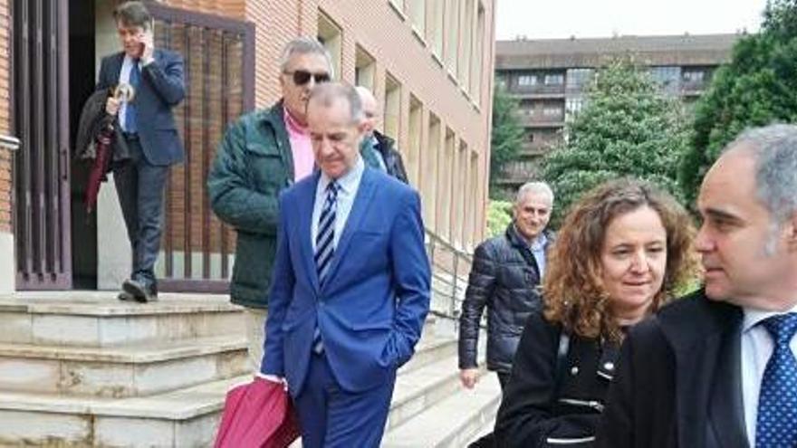 Javier Batalla (en el centro, con paraguas) y Eulalia García-Vallaure, en la entrada de los juzgados durante el juicio,