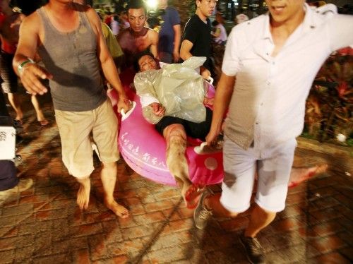 People carry an injured victim from an accidental explosion during a music concert at the Formosa Water Park in New Taipei City