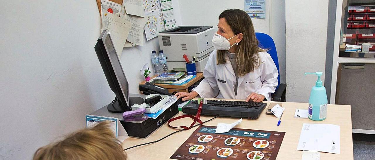 Una médico de familia atiende a una paciente en un centro de salud de Alicante, este abril. | JOSE NAVARRO