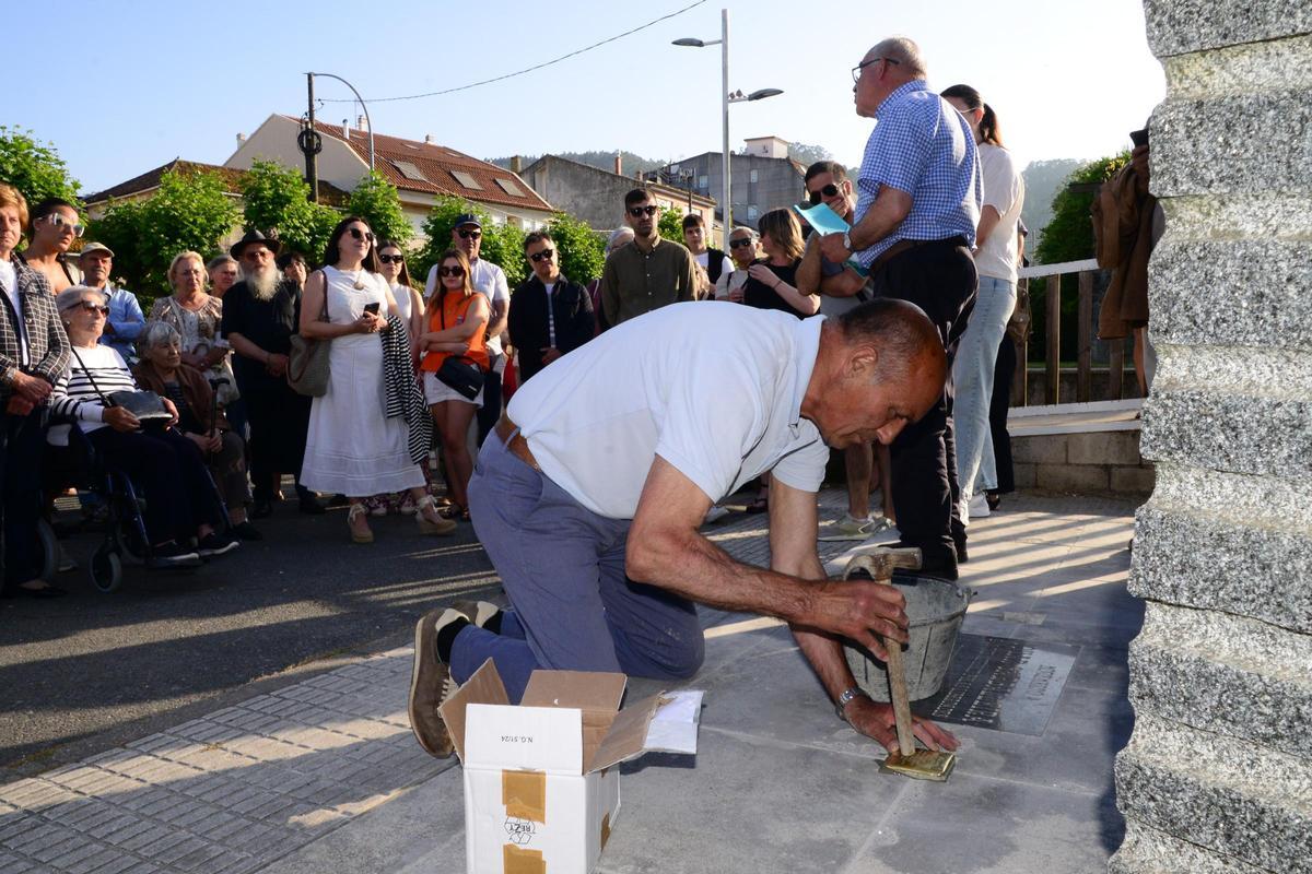 El vecino de Bueu Seso Portela coloca los "stolpersteine" o adoquines de la memoria de Manuel Rey y José Ferradás.