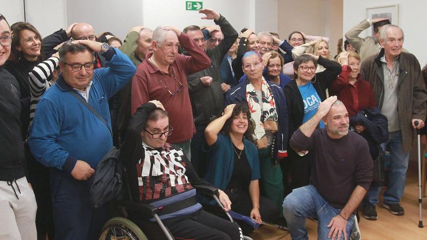 Usuarios y participantes en el acto de la asociación DCA de Ourense realizan el gesto que identifica el daño cerebral adquirido.   | // IÑAKI OSORIO