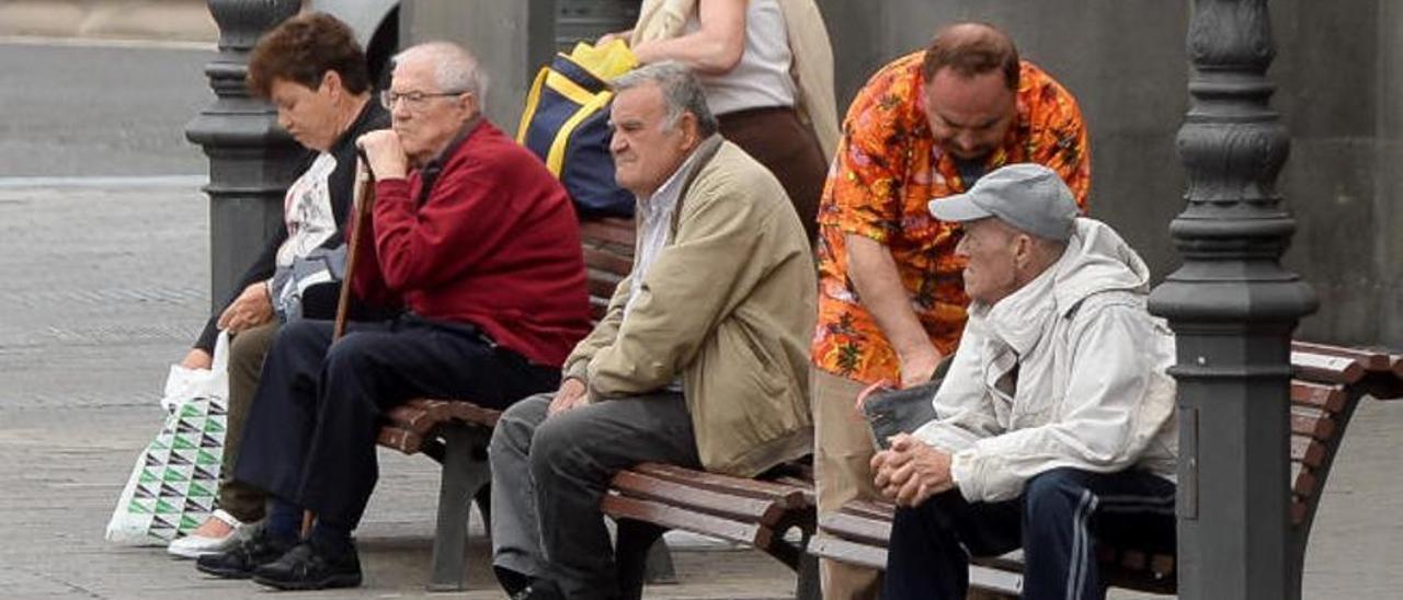 Varios jubilados descansan en una plaza en Tenerife.