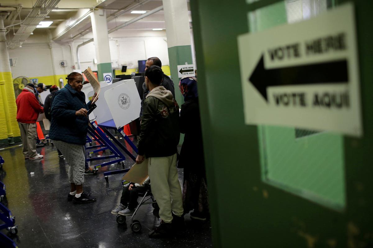 A voter carries her ballot behind a ballot booth during the U.S. presidential election at a polling station in the Bronx Borough of New York, U.S., November 8, 2016. REUTERS/Saul Martinez