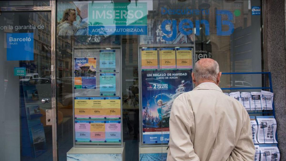 Un jubilado frente al escaparate de una agencia de viajes con ventas del Imserso. | B. RAMON