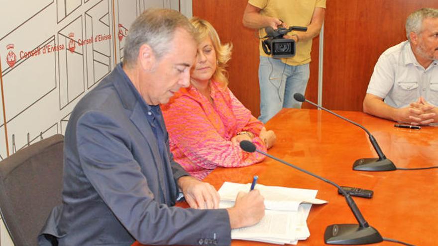 Vicent Serra firma el convenio con los representantes de los trabajadores ante la mirada de Prats.