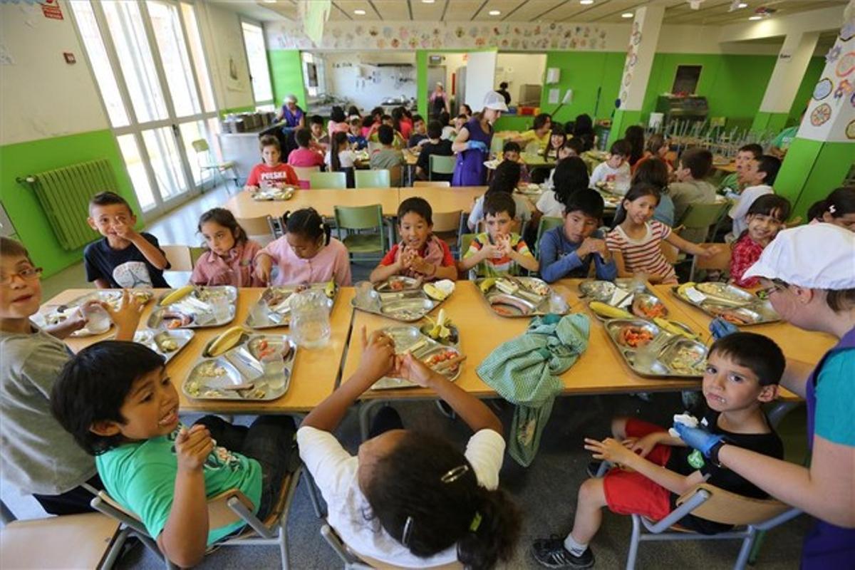 Unas monitoras atienden a los alumnos mayores en el comedor escolar del colegio Antaviana, en el barrio de Roquetes de Barcelona, ayer.