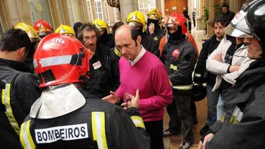 Louzán habla con los bomberos durante una protesta.  // G.Santos