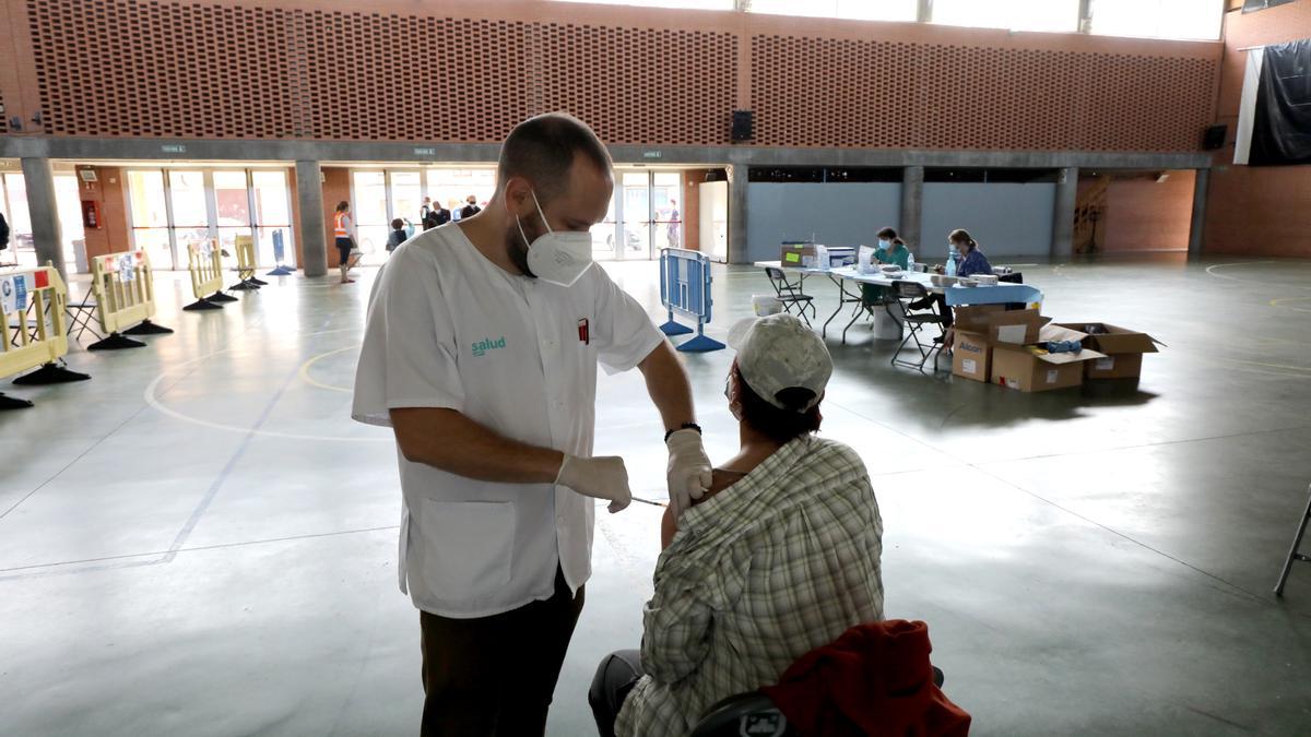 Un enfermero, ayer, pone una vacuna a un trabajador agrícola en La Almunia.