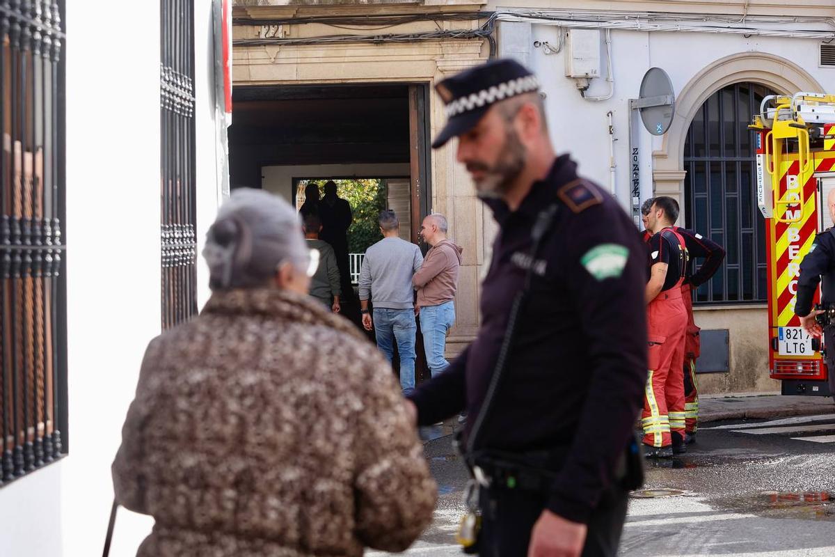 Un Policía conversa con una vecina junto al lugar de los hechos.