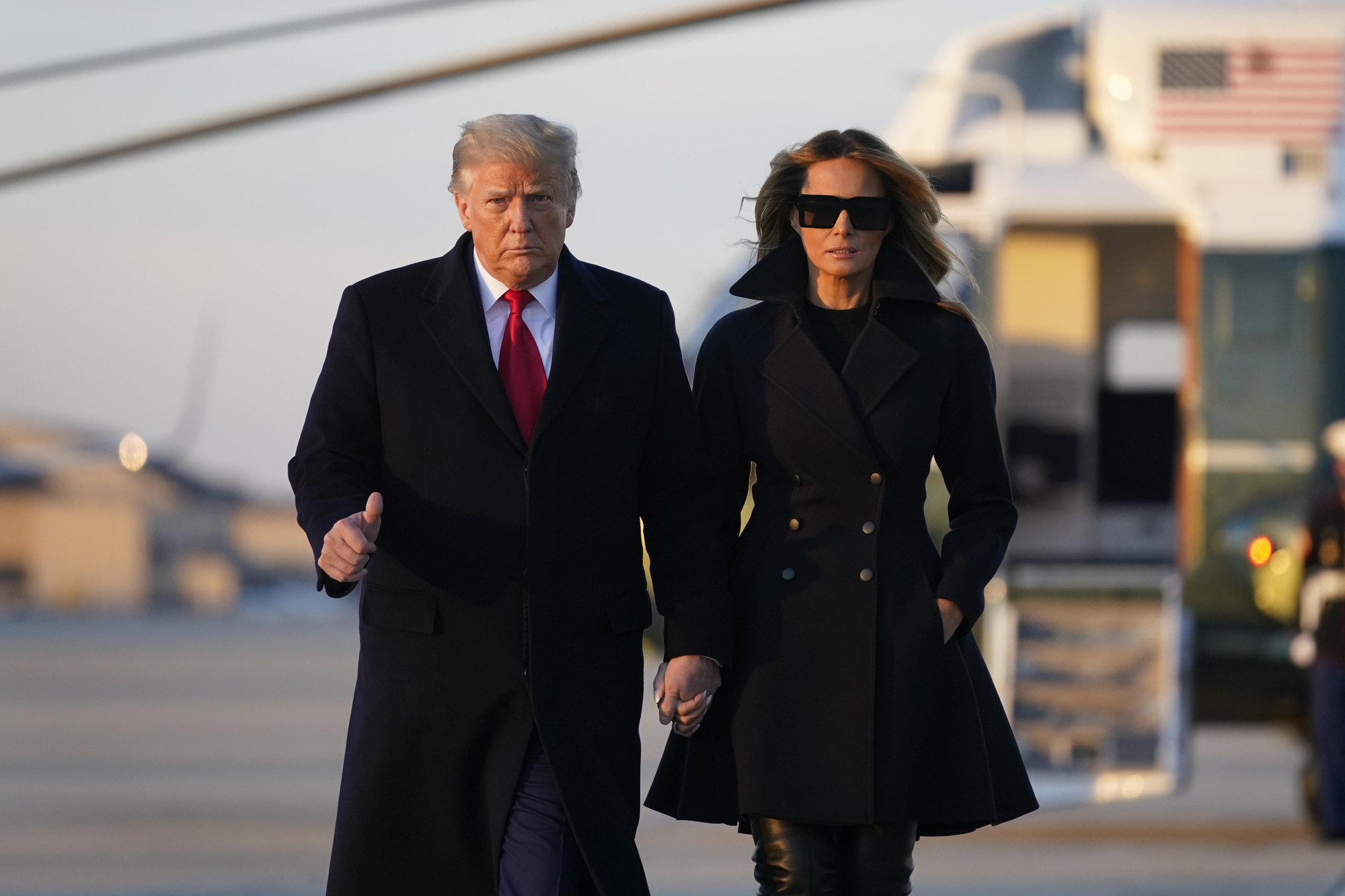 Melania Trump con abigo negro junto a Donald Trump
