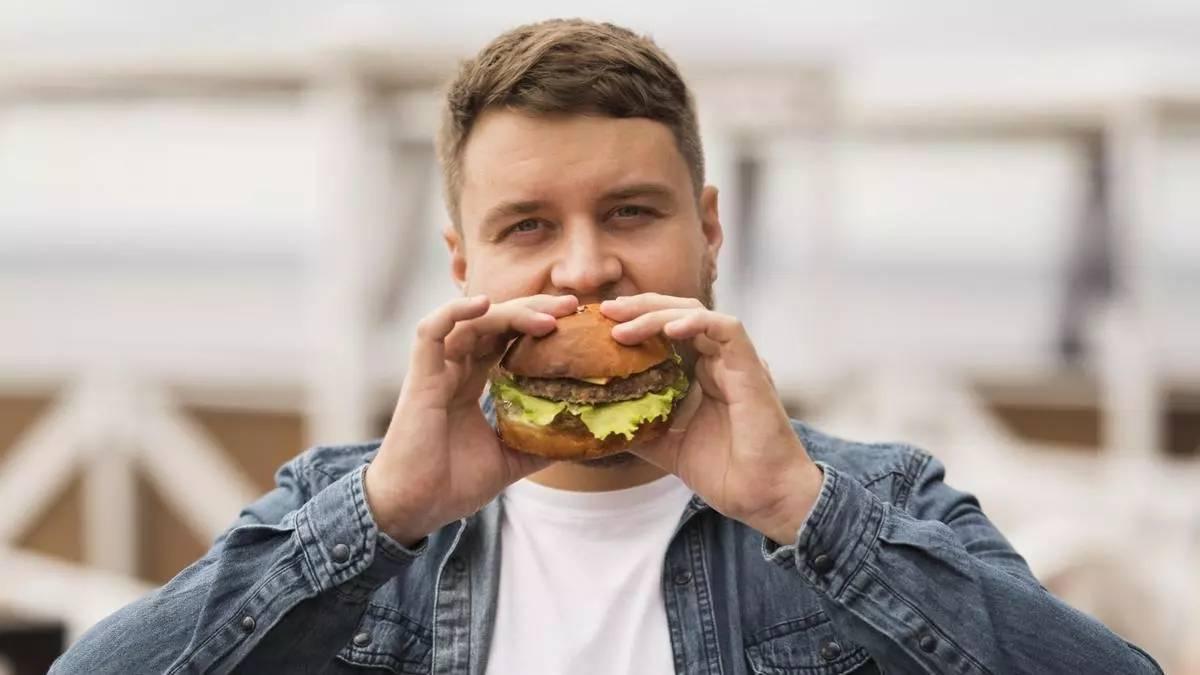 Un home menjant-se una hamburguesa