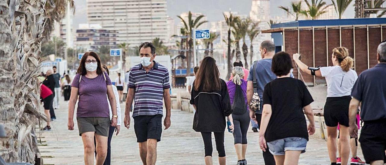 Alicantinos caminan por el paseo de la Playa de San Juan todavía en la Fase 0.