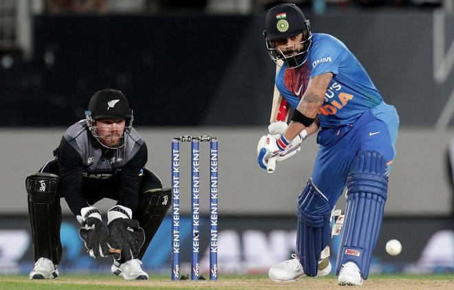 El capitán de la India Virat Kohli (D) batea al lado del guardabosques de Nueva Zelanda Tim Seifert durante el primer partido de cricket Twenty20 entre Nueva Zelanda e India en Eden Park en Auckland.