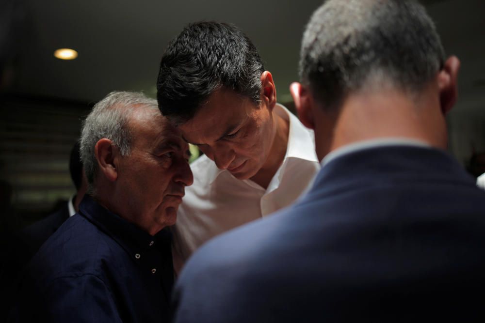 PSOE leader Sanchez listens to a man as he ...