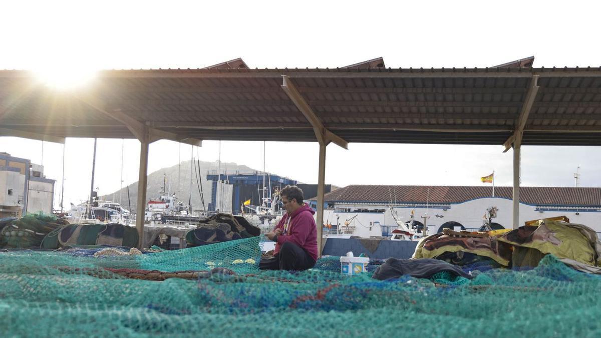 Redes y pescadores en el muelle de Puerto de Santa Lucía, en Cartagena.