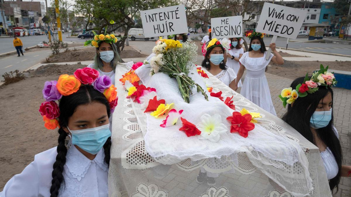 Integrantes del grupo teatral Vichama ejecutan una procesión mortuoria bajo el título “¡Nos queremos vivos!”. Portando un cuerpo simulado y mostrando carteles alusivos al Día Internacional de la Eliminación de la Violencia contra la Mujer, en el populoso distrito de Villa en El Salvador.