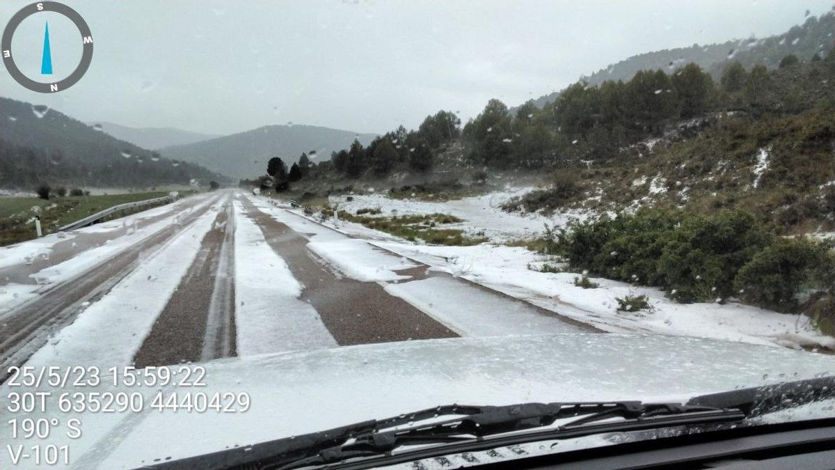 El granizo cubre de blanco una carretera y el monte en Ademuz, ayer.