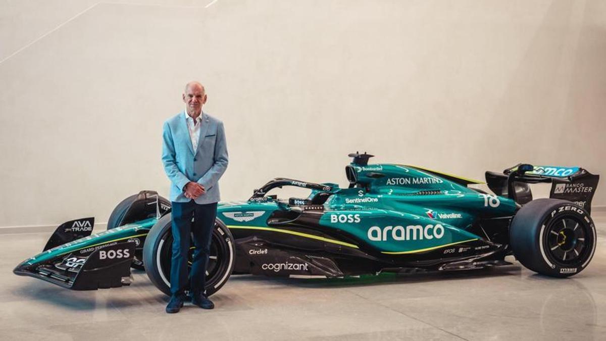 Adrian Newey posa junto a un coche de Fórmula 1 de Aston Martin.