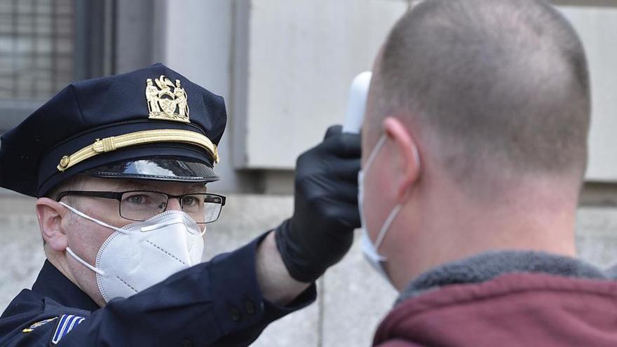 Un policía toma la temperatura a un hombre en Nueva York.