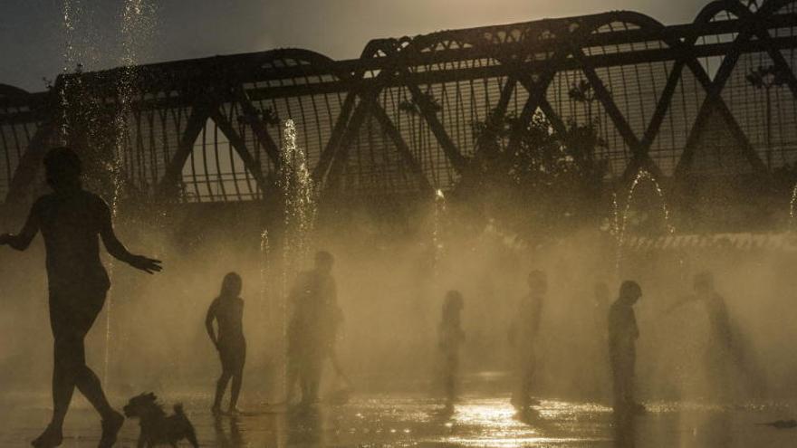 Varias personas se refrescan en las fuentes de Madrid Río