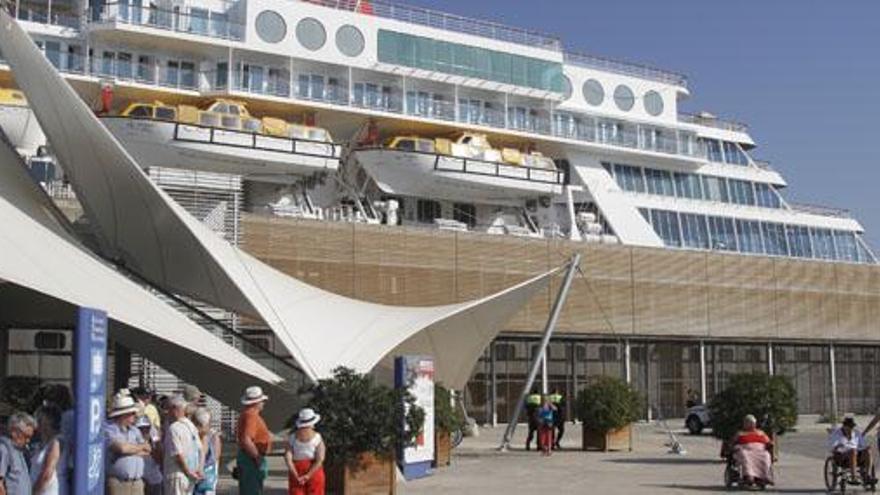 Pasajeros de un crucero turístico esperan la llegada de autobuses o taxis en la terminal de cruceros del Puerto de Alicante