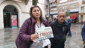 Rocío Caparrós, antigua usuaria del albergue para personas sintecho de Badalona, sostiene el blister donde guarda las pastillas que ha de tomar. Le acompaña Carlos García, también usuario de Can Vofí Vell