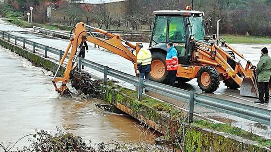 Una máquina de la Diputación actúa en el puente durante la última avenida del río Aliste.