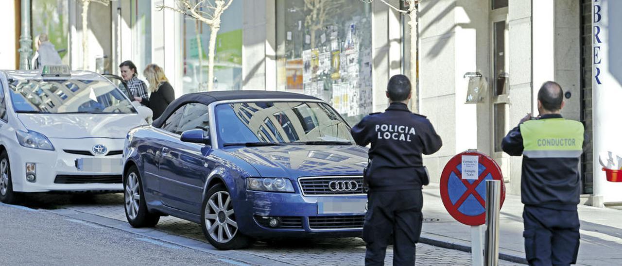 Un policía fotografía un vehículo multado. // Marta G. Brea