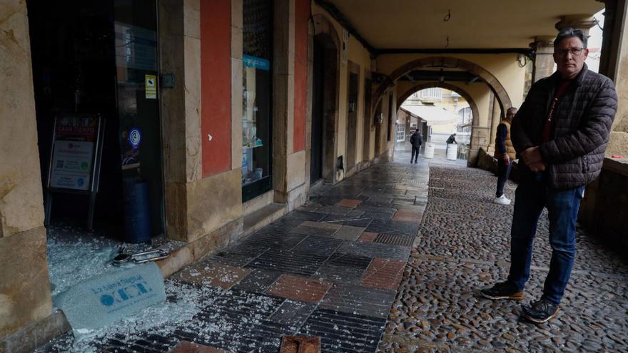 El propietario del comercio asaltado, frente a la puerta rota.