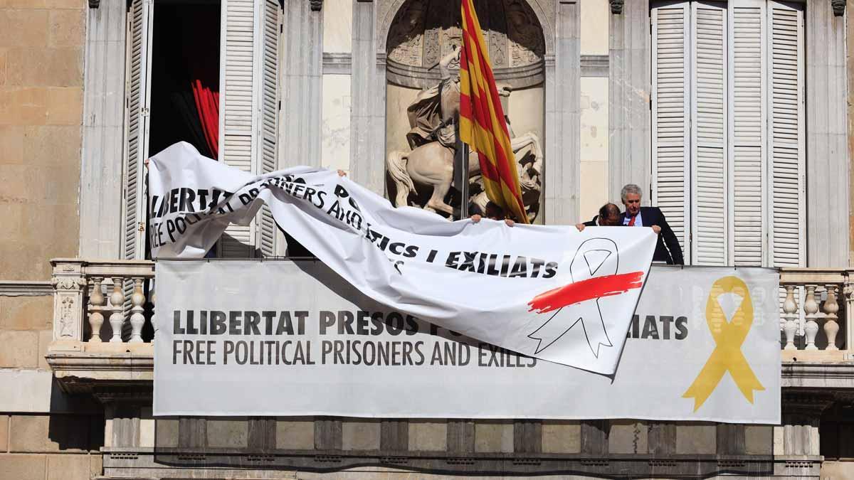 Momento en el que se cambia la pancarta con el lazo amarillo por otra con un lazo blanco en la Generalitat