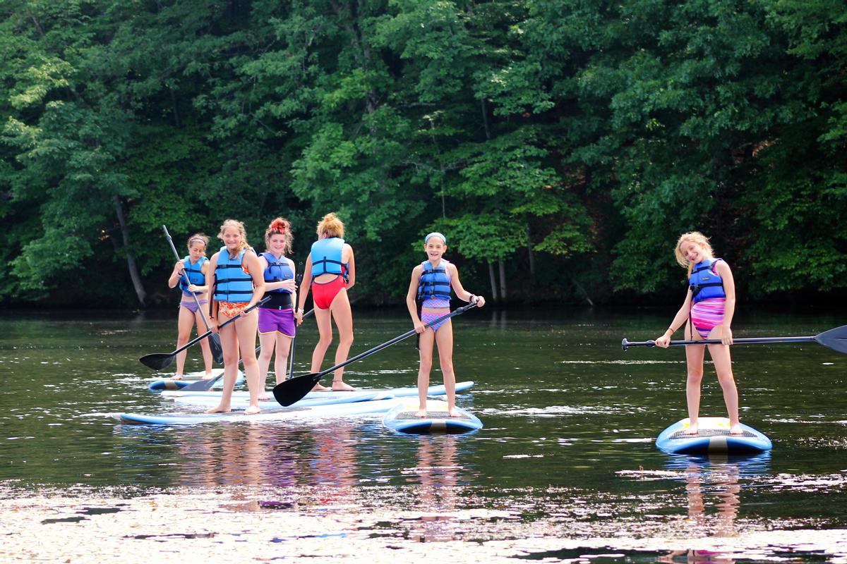 Un grupo de niñas practicando paddle surf.