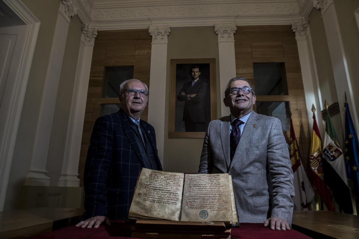 Santos Benítez Floriano y Fernando Jiménez Berrocal, Cronistas Oficiales de Cáceres, junto al Fuero de la ciudad, en el Salón de Plenos del ayuntamiento.