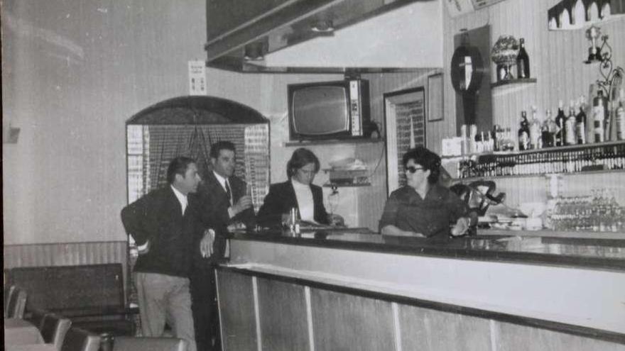 A señora Delvia, detrás da barra, ao lado do autor deste artigo e Camilo do Café-Bar López e Manolo do Café Español, ramistas das festas de 1972 xunto a &#039;Celso O Perkins&#039;. // Bernabé