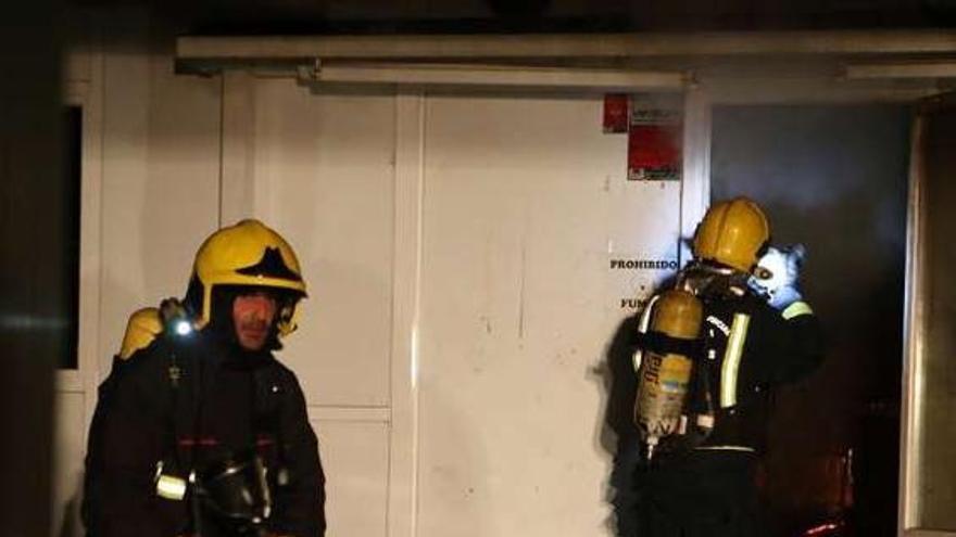 Bomberos durante su trabajo en el interior del local, en Tomiño.