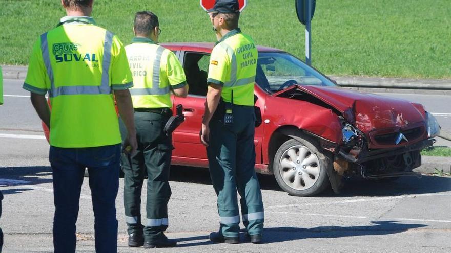 Dos guardias civiles observan uno de los coches siniestrados.