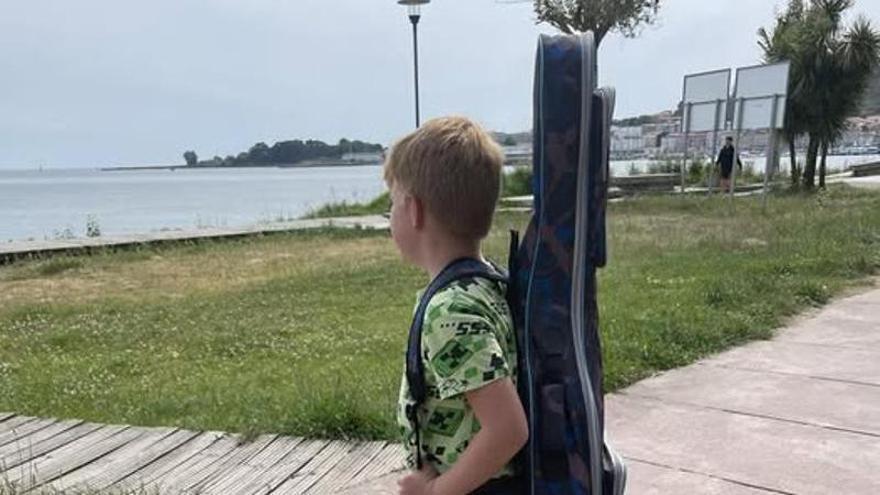 Misha, en el paseo de la playa de Rodeira con la guitarra a su espalda.
