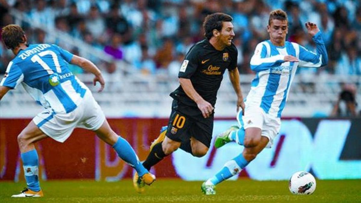 Zurutuza zancadillea a Messi ante Griezmann durante el partido de ayer en Anoeta.