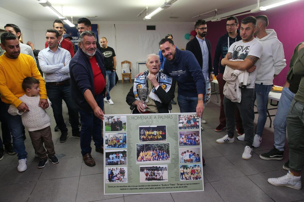 Manuel Palmás con el panel con las fotografías antiguas de los equipos a los que entrenó.