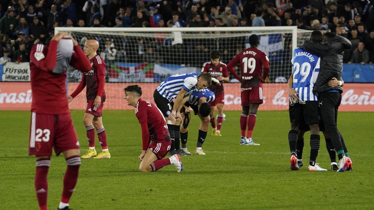 Manu Molina, Mollejo y Francés, desesperados al final del partido mientras los jugadores del Alavés celebran el triunfo.