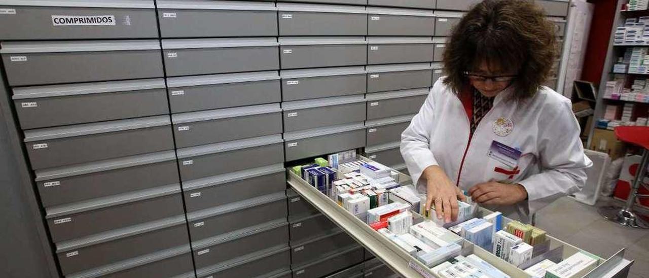 Una trabajadora de una farmacia de Vigo busca un medicamento. // Marta G. Brea