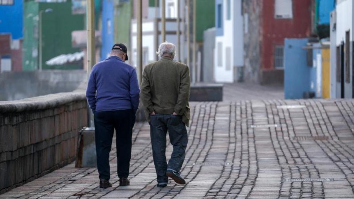 Dos ciudadanos caminan por el paseo marítimo del barrio de San Cristóbal, en la capital grancanaria.