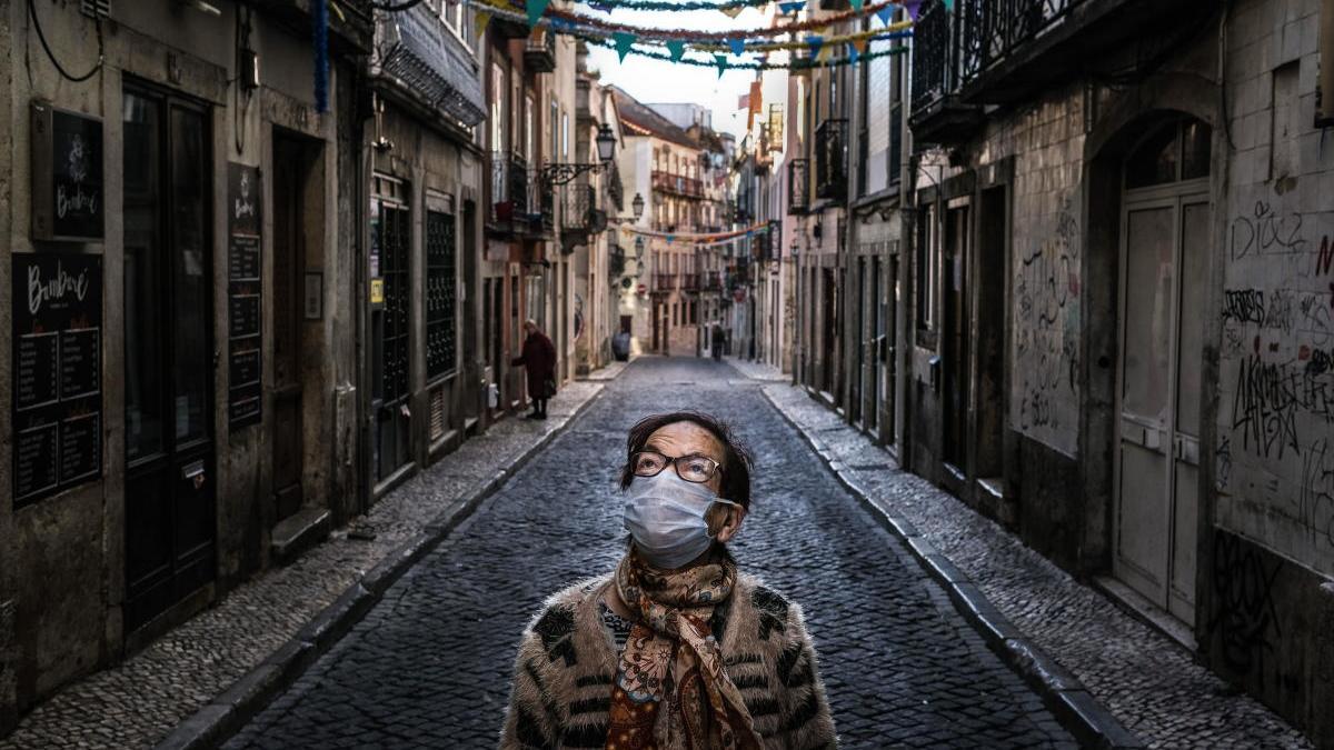 Una mujer camina por una calle desierta de Lisboa al inicio de la pandemia. // Mario Cruz