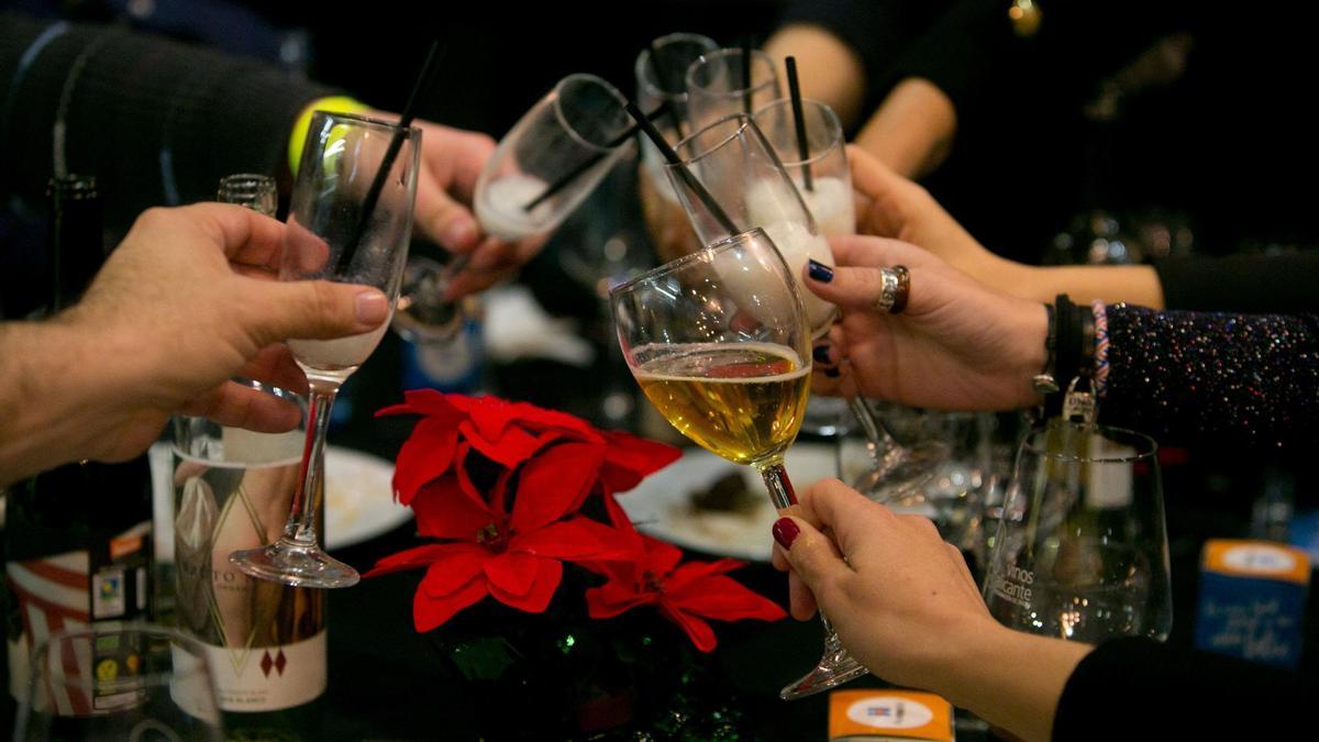 Varias personas brindan en una cena de Navidad.